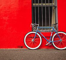 Fixed Gear (Fixie) Bicycle Against a Red Wall by jamjarphotos