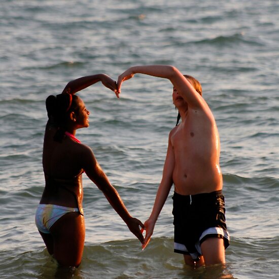 Black and white human arms shape heart